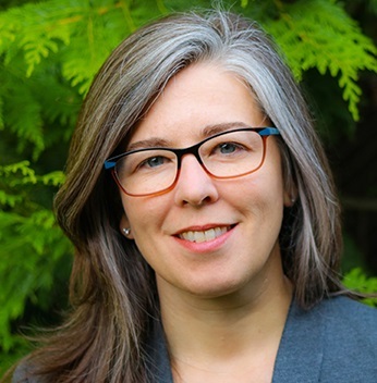 Julie Risien outside in front of leaves