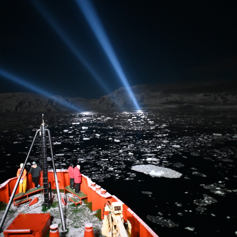 Polar research vessel at night among pack ice