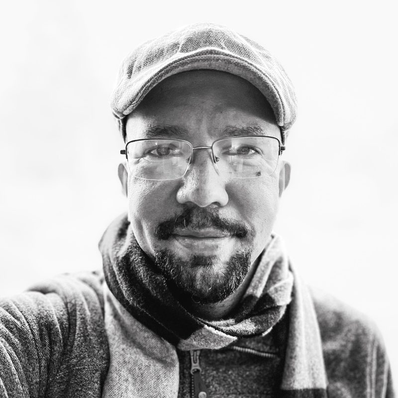 Walter Kitundu in black and white in front of a blank background