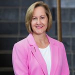 Laurie in front of a tiled wall