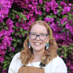 Meghan in front of bright purple flowers