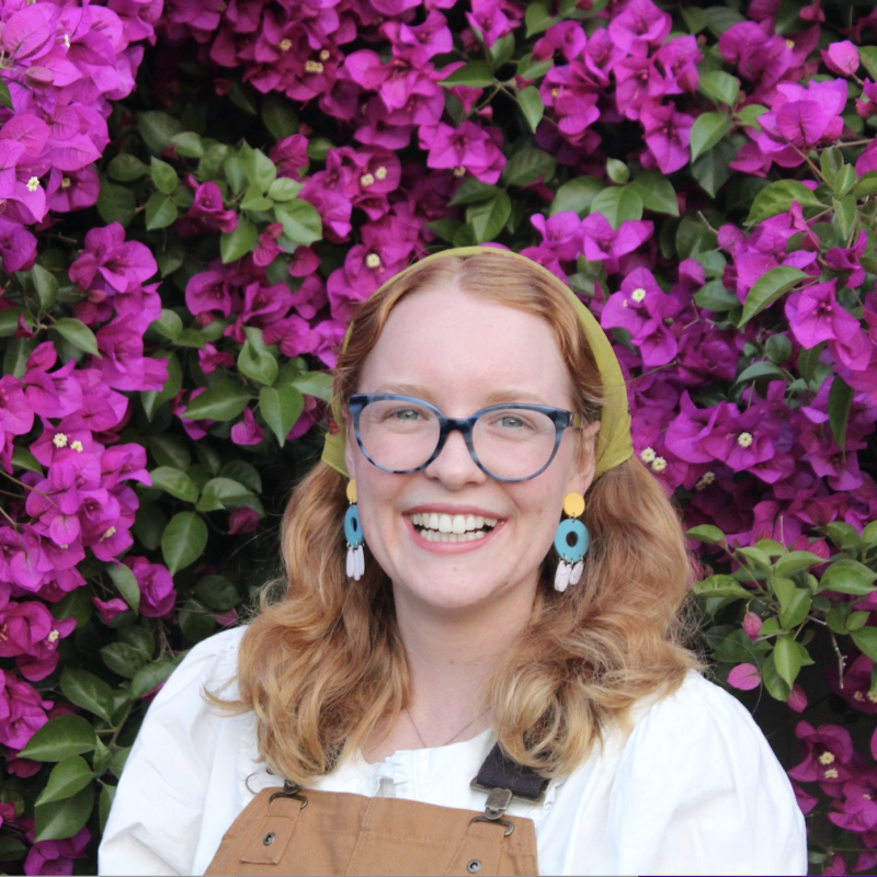 Meghan in front of bright purple flowers
