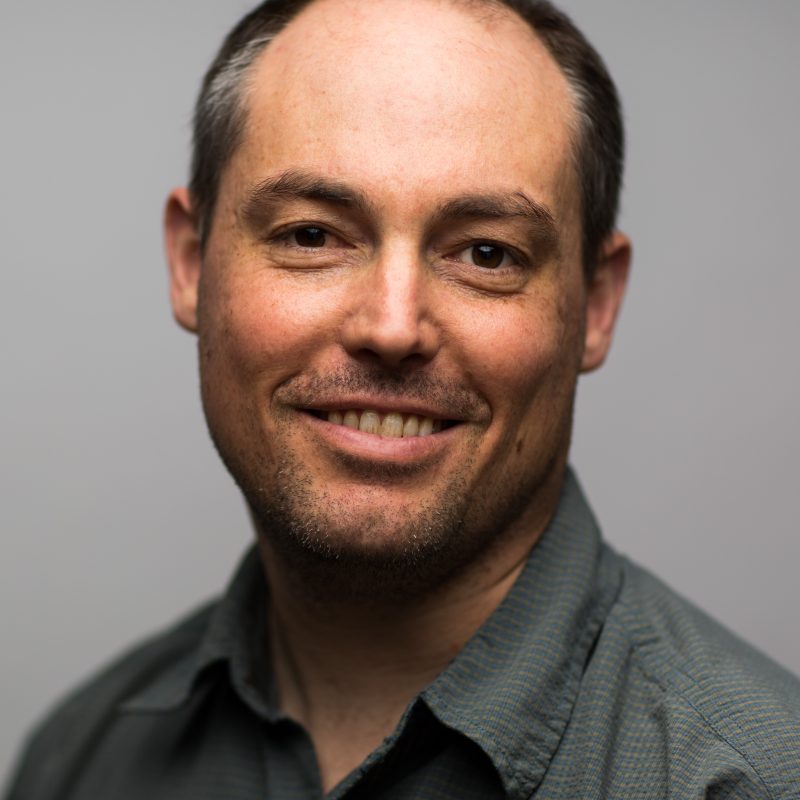 T.J. in front of a gray background