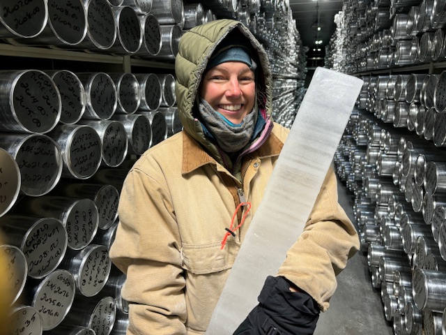 A smiling woman holding an ice core