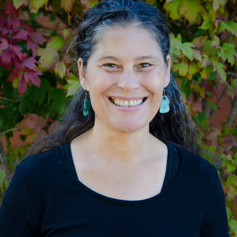 Renee smiling in front of a tree