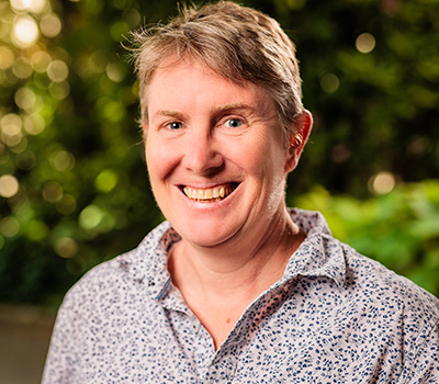 Jenny smiling in front of trees