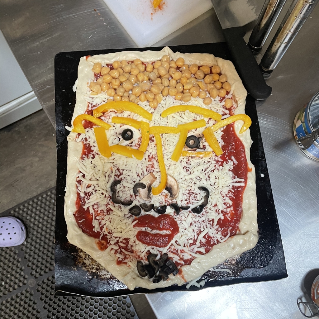 Pizza with the toppings arranged to look like a face