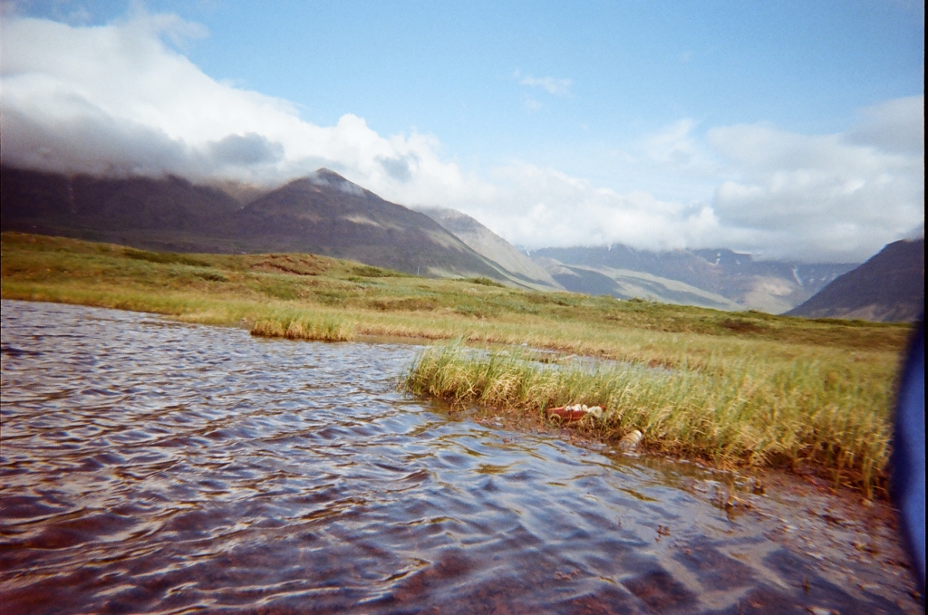 Film photo of a small pond created by thawing permafrost on the tundra plateau above Anaktuvuk Pass.
