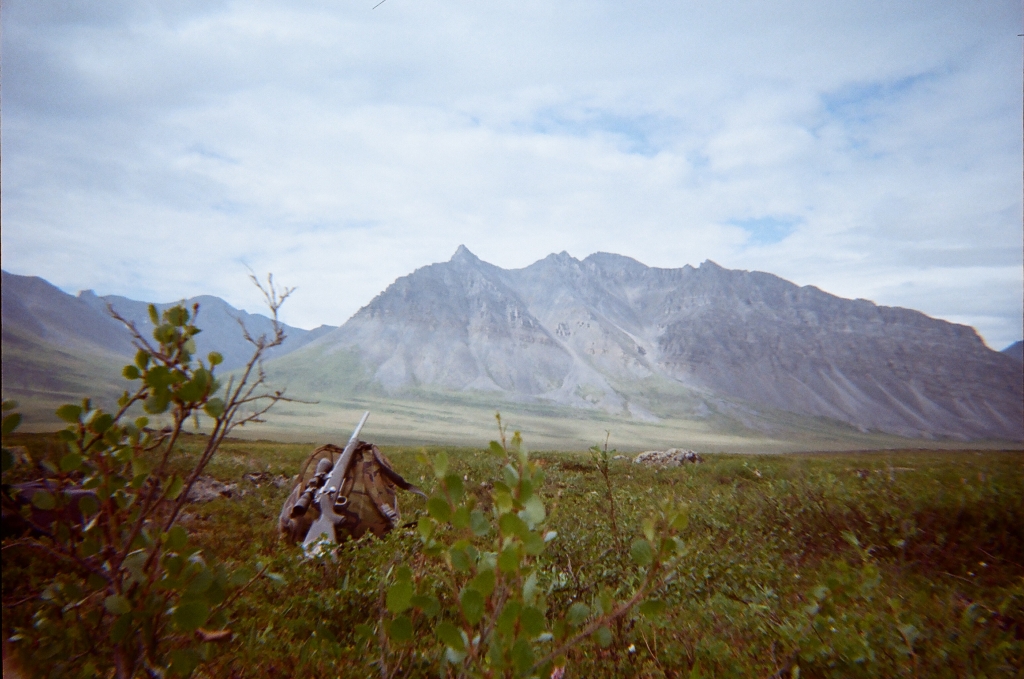 Film photo of a local partner's hiking pack and gun sitting on the tundra during a hike outside the village.