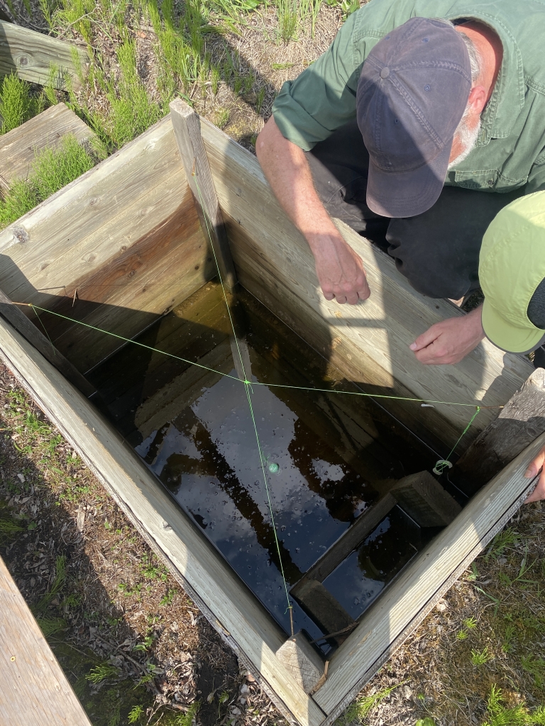 Mike Koskey and Yoko Kugo observe both the flooding of the ice cellar, as well as the raised permafrost visible two feet below the water's surface.