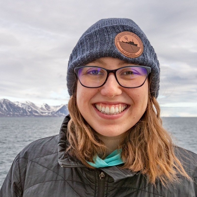 Emelia in front of a body of water and mountains