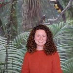 Jacklyn in front of a background with tropical trees and birds