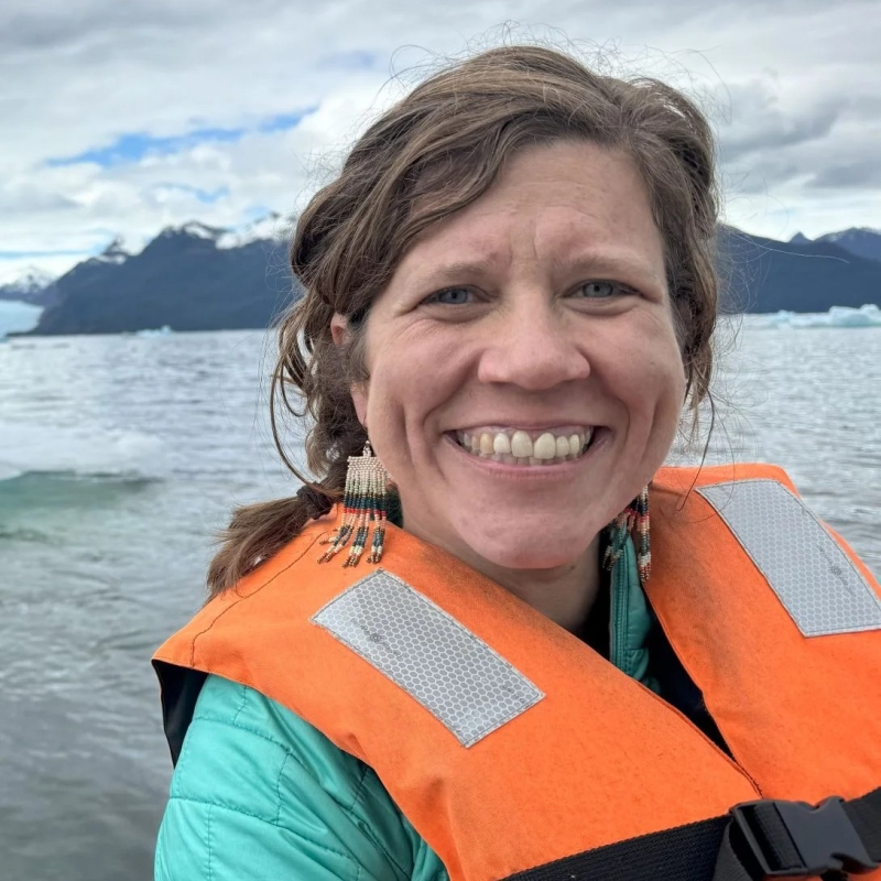 Sarah wearing a life jacket with water in the background