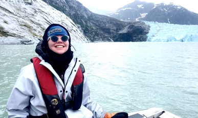 A woman smiling with a glacier in the background