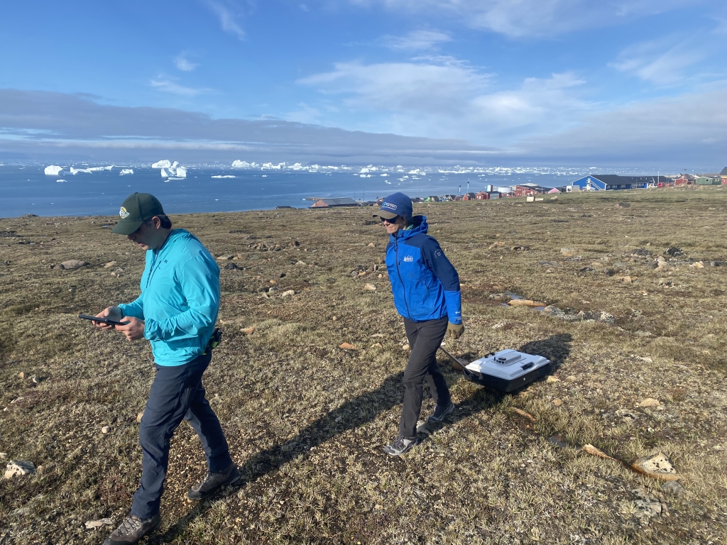 One person looks at an ipad while another pulls the instrument behind them