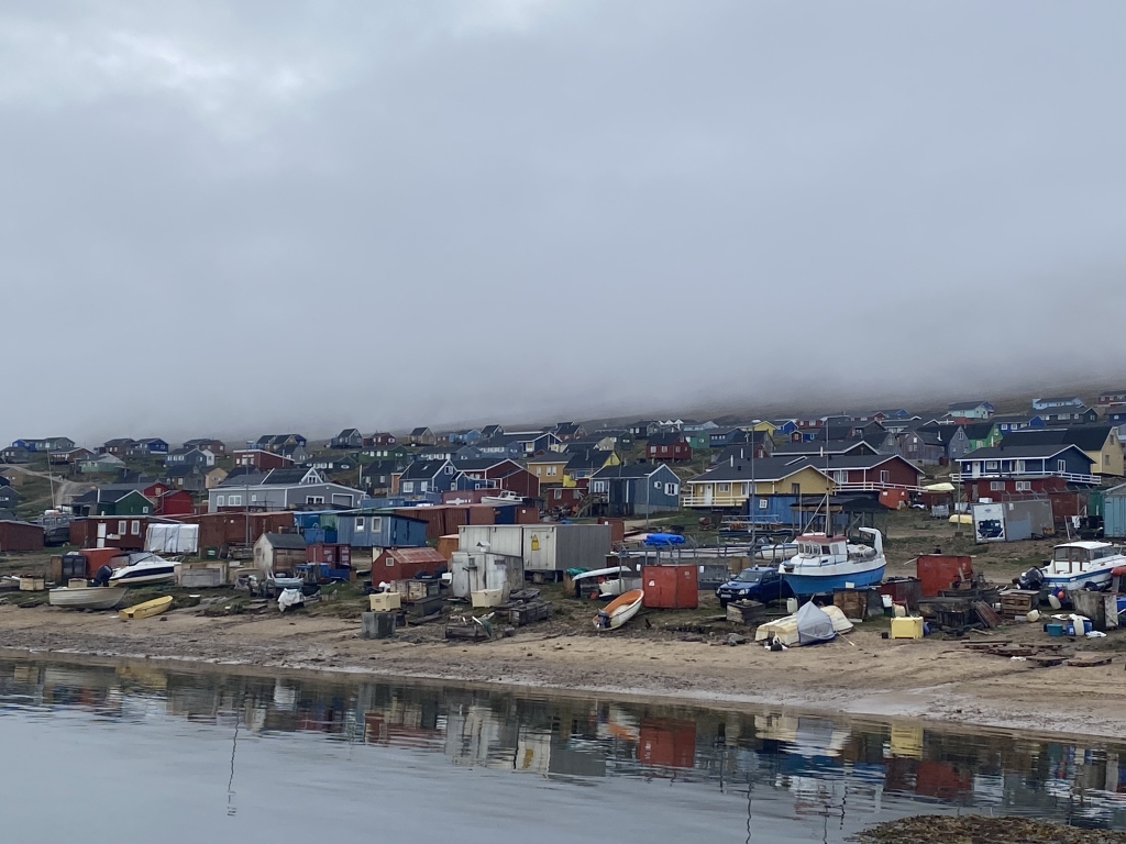 A bunch of colorful homes with a completely gray foggy sky above them.