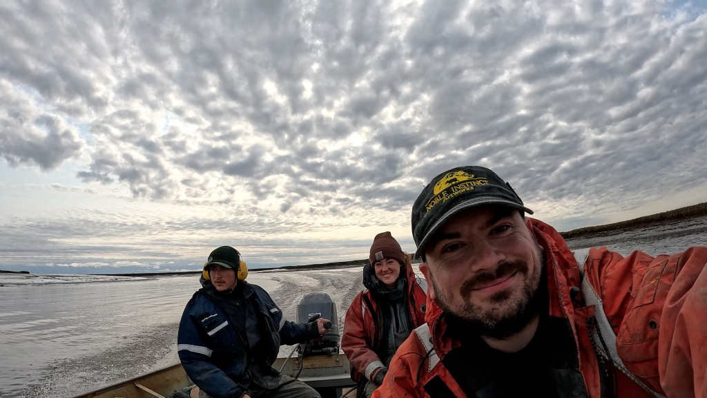 Three people smiling in a boat