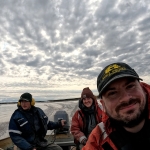 Three people smiling in a boat