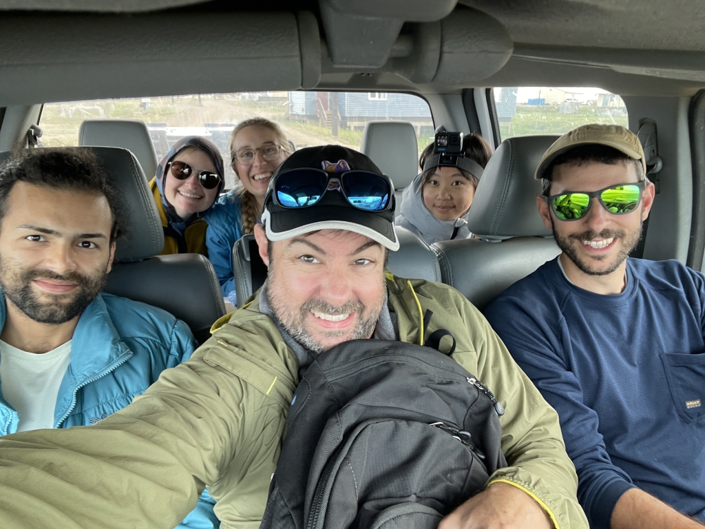 A group of people smiling in a car. 