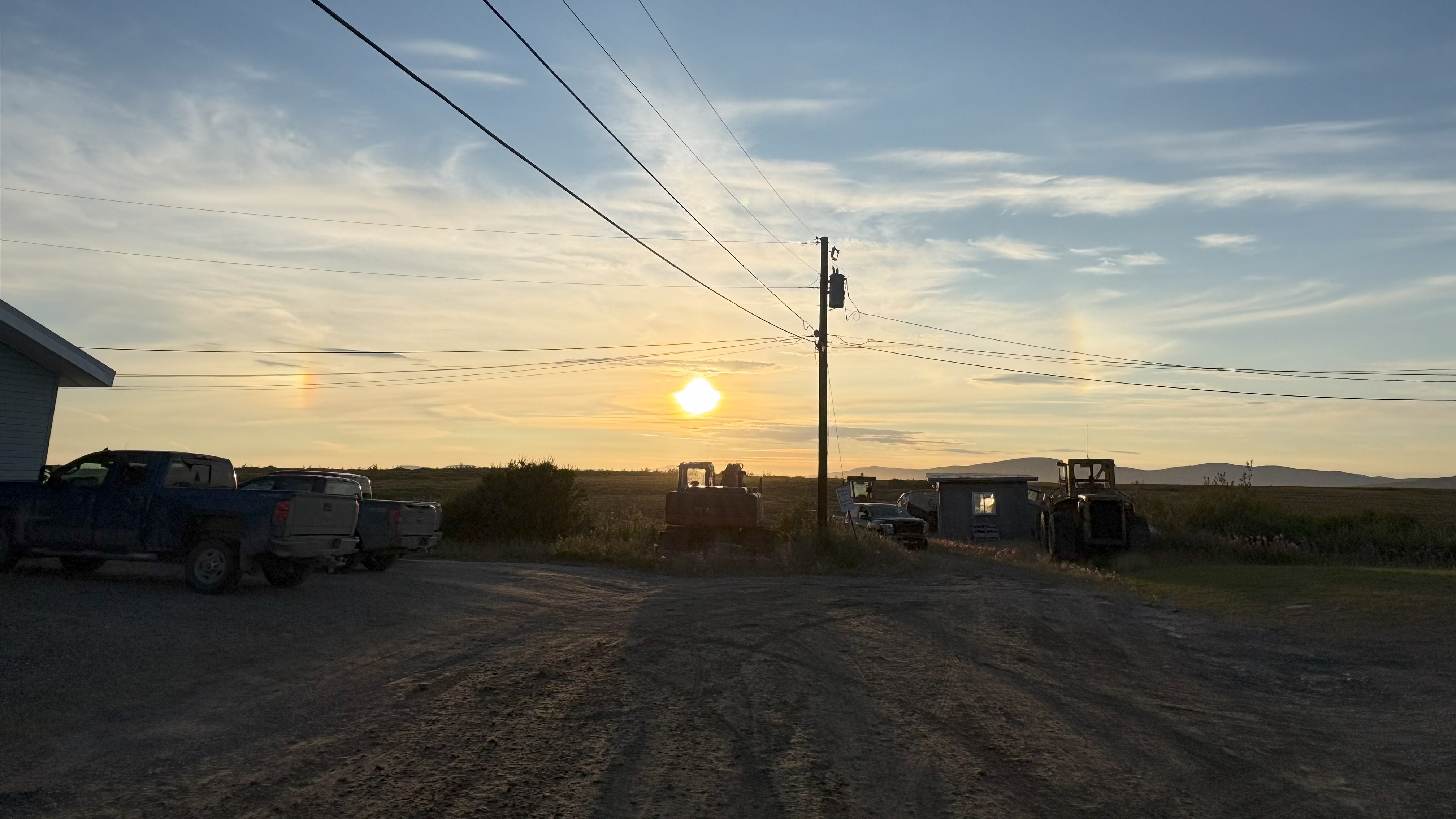 Spots of light on either side of a sun that is low on the horizon