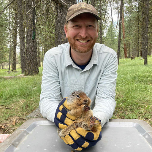 Austin wearing thick gloves holding a squirrel