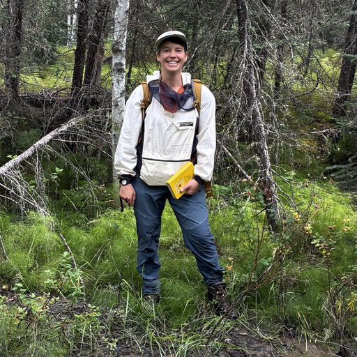 Louise standing in front of trees