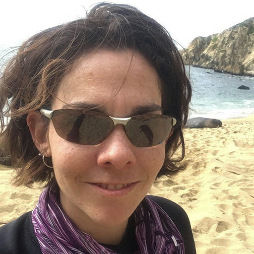 Rachel wearing sunglasses on a beach