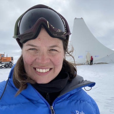 Steph wearing goggles in front of a snowy background