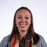 Tricia smiling in front of a white background