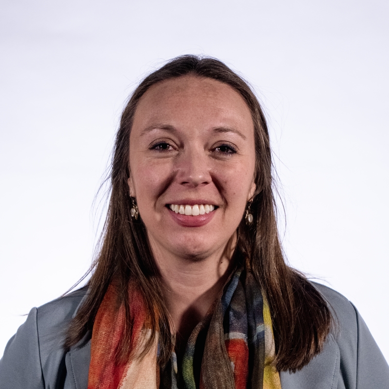 Tricia smiling in front of a white background