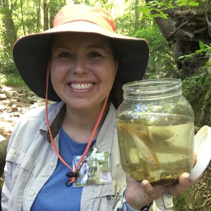 Eric holding up a jar with water and fish inside
