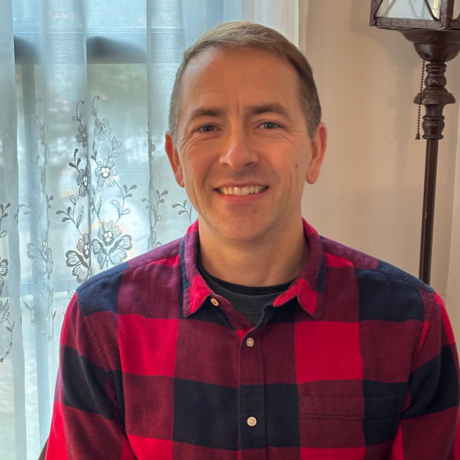 Jeff smiling with a window in the background