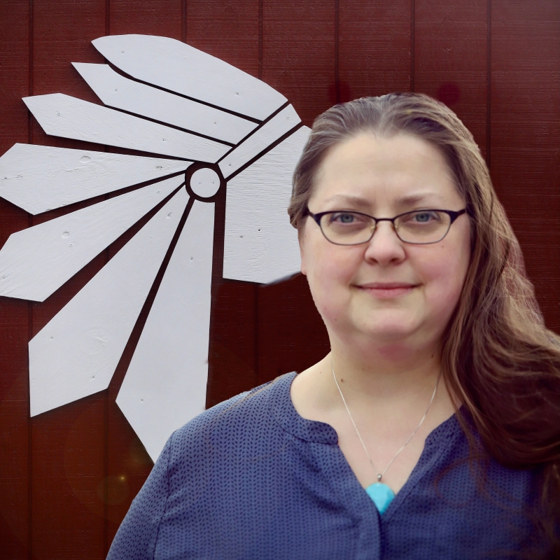 Stephanie in front of a red wall and Wilton-Lyndeborough Cooperative Middle High School mascot