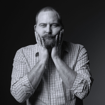 Black and white photo of Tom with his hands on his cheeks