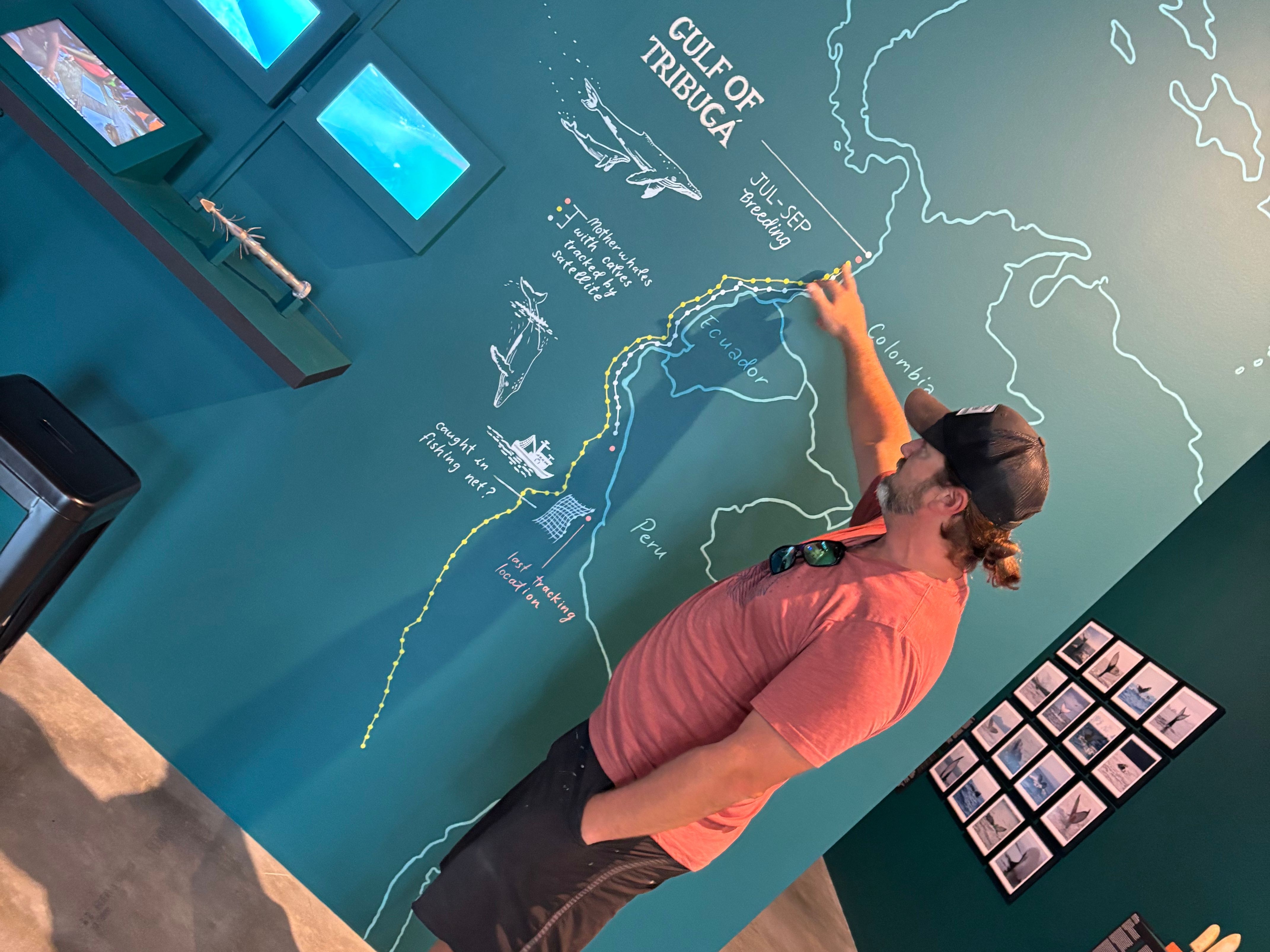 A man points at a map drawn on a wall
