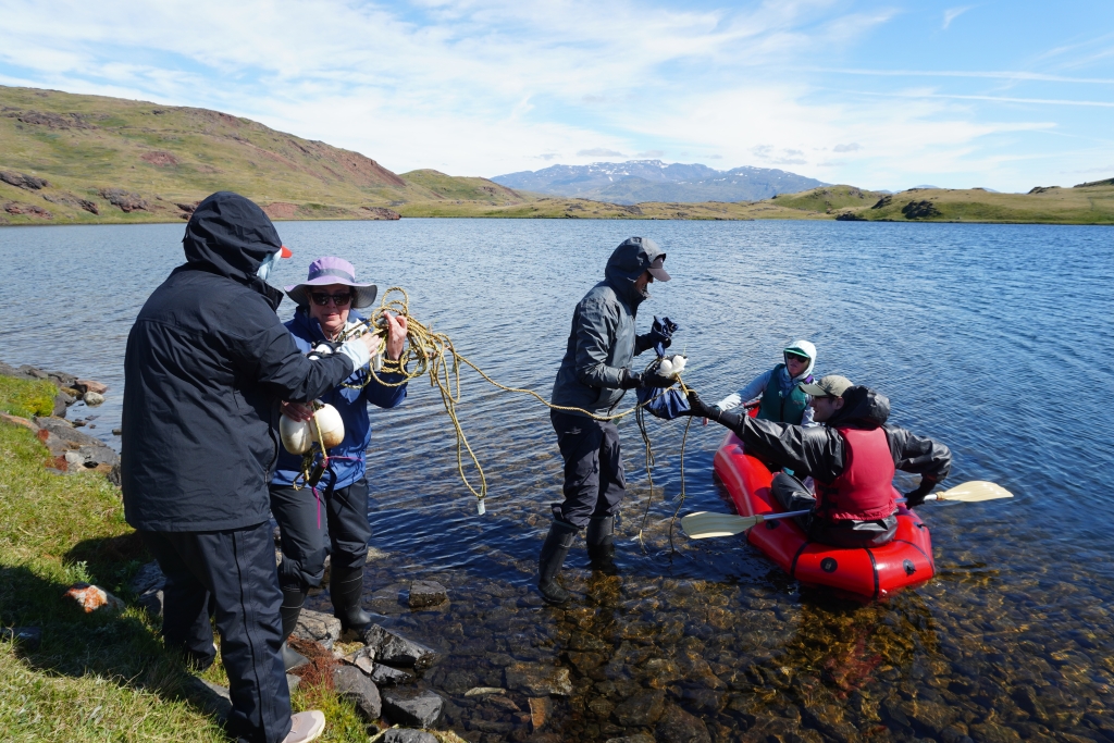 Research team members Avery Lamb, Jasmine Saros, and Margaret O'Brien help unload buoys from the boat with Amanda Gavin and Thomas Grindle