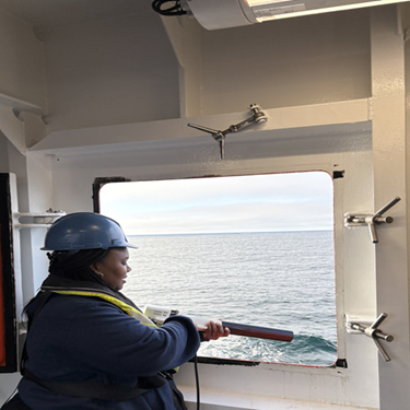 The author using equipment through the open window of the ship