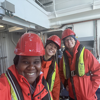 The author and two other people wearing safety vests and helmets pose smiling looking at the camera