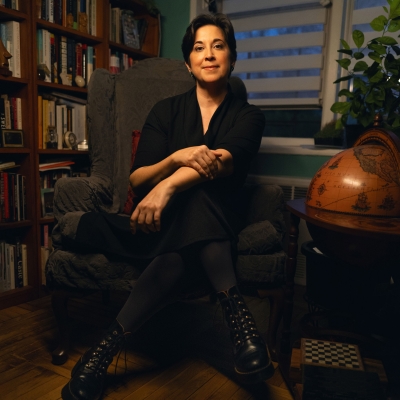 Kamala poses in a library next to a large globe