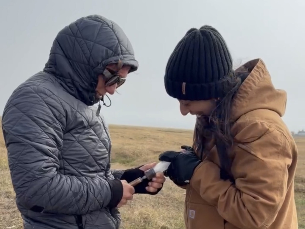 Two people work together to filter porewater