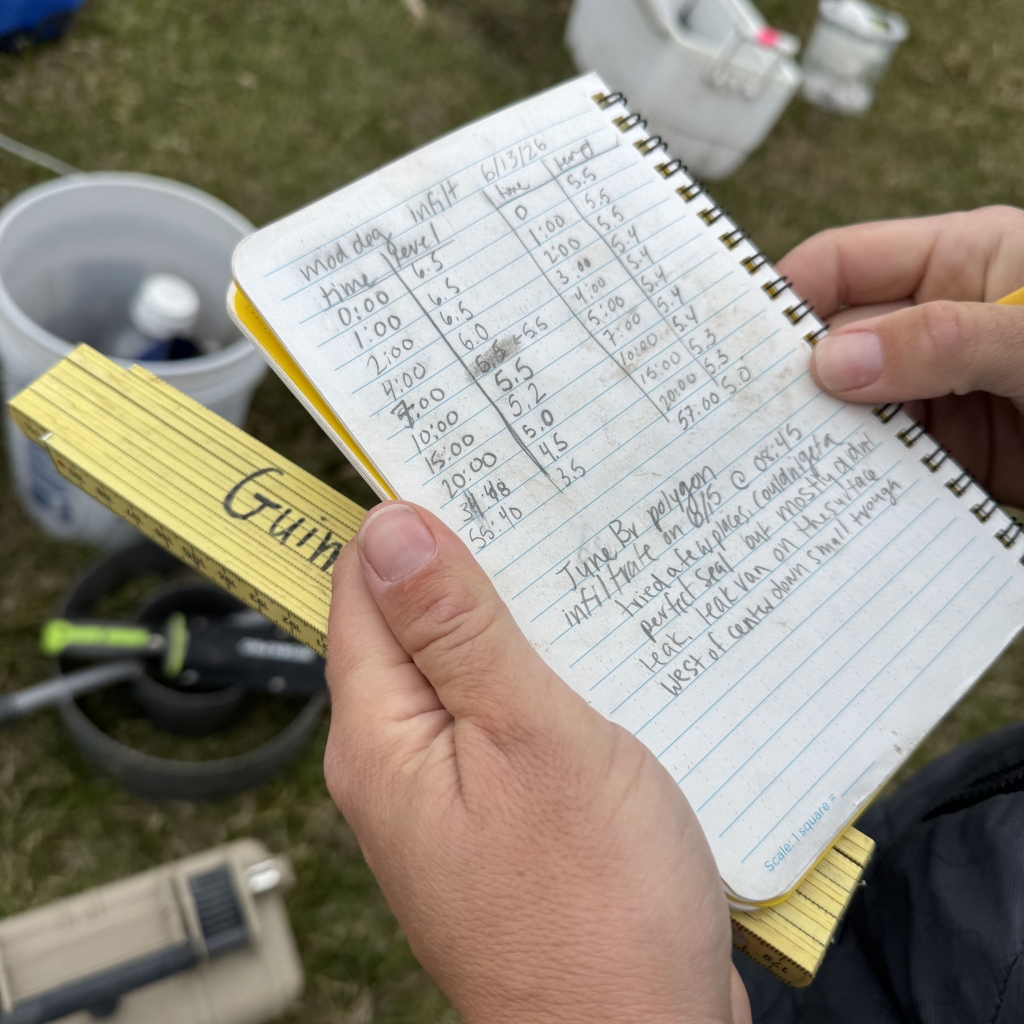Close up of hands holding a notebook with a data log written inside