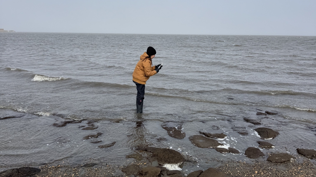 Lauren standing in the ocean collecting data