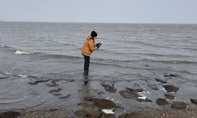 Lauren standing in the ocean collecting data