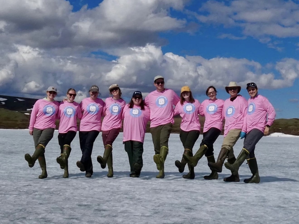 10 people with arms around each other wearing matching pink shirts with marshmallows on them