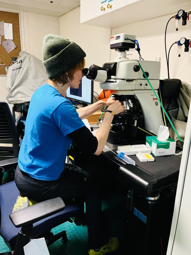 Madeline looking into microscope